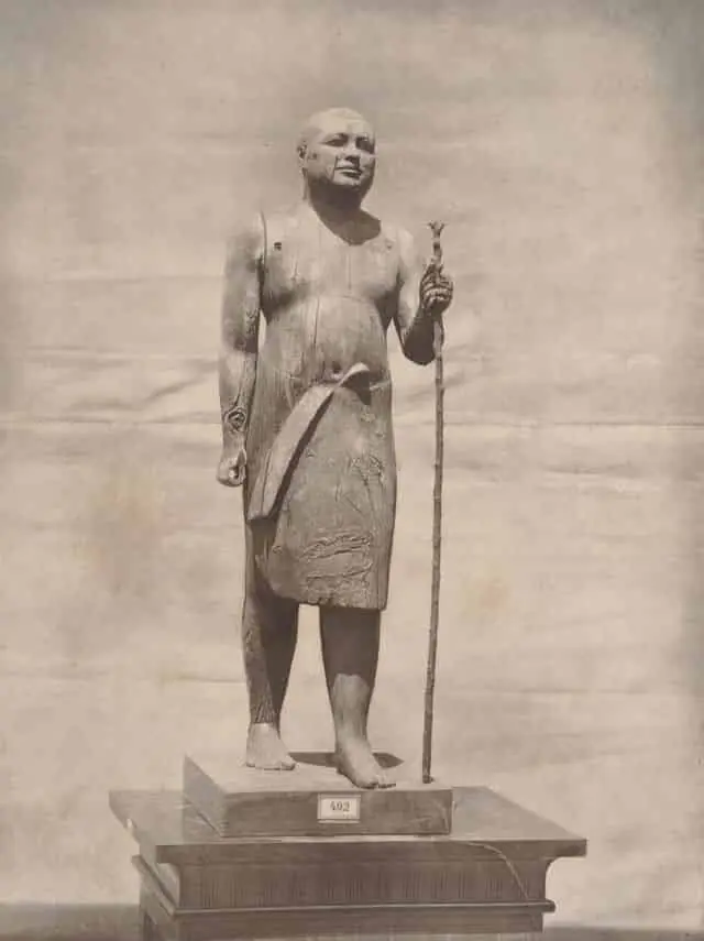 Estátua de Madeira do Padre Lector Kaaper, Escultura Egípcia da 5ª Dinastia, Arqueologia da Necrópole de Saqqara, Arqueologia do Antigo Egito, Escultura em Madeira do Império Antigo, Técnica de Escultura Egípcia, Arte e Cultura do Reino Antigo, Significado Simbólico das Estátuas Funerárias, Conservação de Artefatos Arqueológicos, Influência da IV Dinastia na Arte Egípcia, Técnicas de Escultura em Madeira, Descobertas de Auguste Mariette, Estilo "Verístico" na Escultura Egípcia, Realismo na Arte do Antigo Egito, Religião e Espiritualidade no Egito Antigo, Contexto Histórico da 5ª Dinastia, Importância da Necrópole de Saqqara, Vida Social no Antigo Egito, Papel dos Sacerdotes na Sociedade Egípcia, Materialidade na Escultura Antiga, Arte Funerária e Práticas Mortuárias, Reconstrução Histórica através de Artefatos, Museologia e Exposição de Artefatos Egípcios.