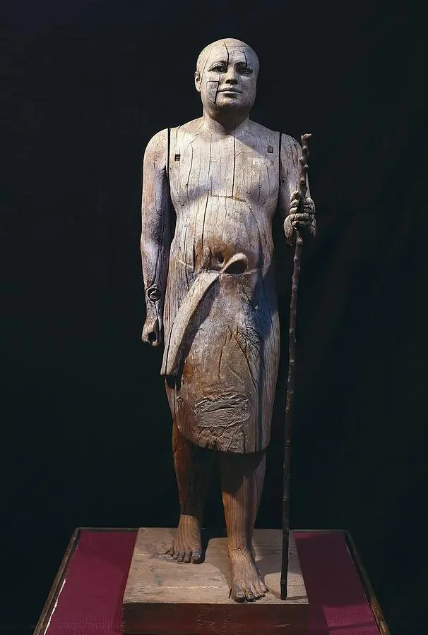 Estátua de Madeira do Padre Lector Kaaper, Escultura Egípcia da 5ª Dinastia, Arqueologia da Necrópole de Saqqara, Arqueologia do Antigo Egito, Escultura em Madeira do Império Antigo, Técnica de Escultura Egípcia, Arte e Cultura do Reino Antigo, Significado Simbólico das Estátuas Funerárias, Conservação de Artefatos Arqueológicos, Influência da IV Dinastia na Arte Egípcia, Técnicas de Escultura em Madeira, Descobertas de Auguste Mariette, Estilo "Verístico" na Escultura Egípcia, Realismo na Arte do Antigo Egito, Religião e Espiritualidade no Egito Antigo, Contexto Histórico da 5ª Dinastia, Importância da Necrópole de Saqqara, Vida Social no Antigo Egito, Papel dos Sacerdotes na Sociedade Egípcia, Materialidade na Escultura Antiga, Arte Funerária e Práticas Mortuárias, Reconstrução Histórica através de Artefatos, Museologia e Exposição de Artefatos Egípcios.
